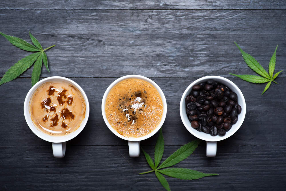 top view of cups of coffee with cannabis leaves, and cup of roasted beans 