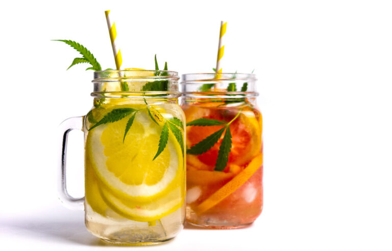 Grapefruit and lemon juice with marijuana leaves in a glass