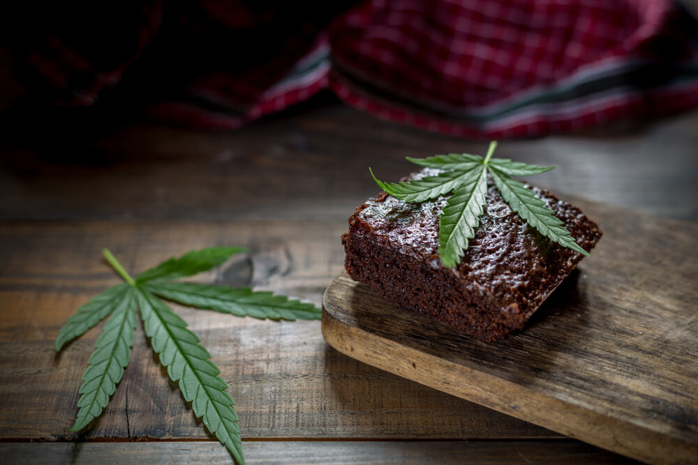 cannabis brownie with marijuana leaf on wooden table 