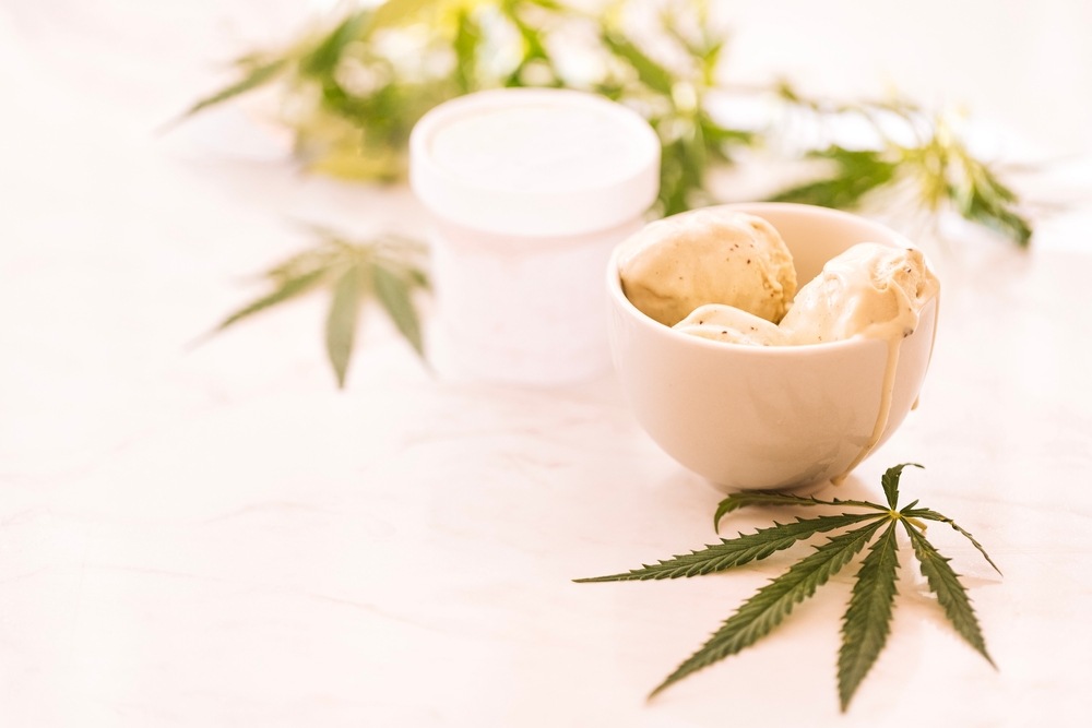 cannabis infused ice cream in white bowl with marijuana leaves