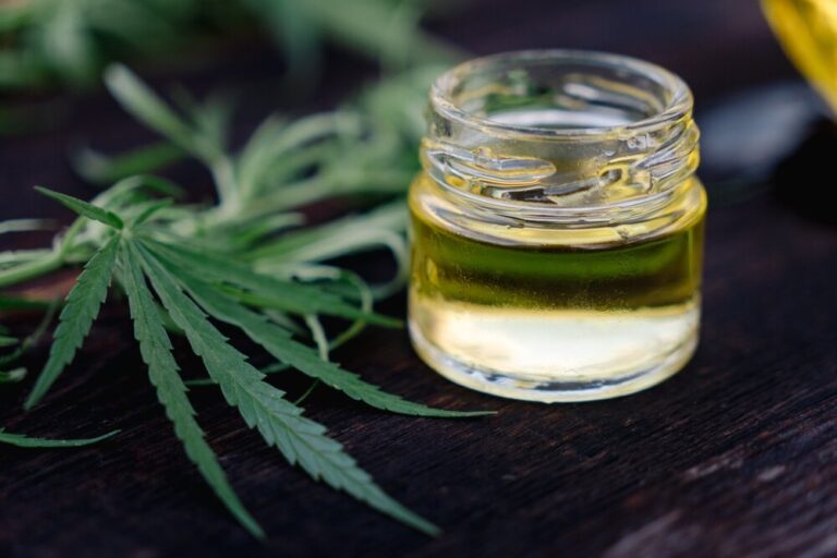 cannabis oil in glass jar with cannabis leaf