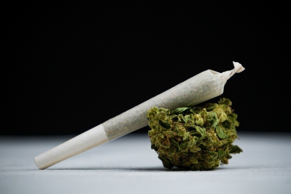 a rolled joint on top of a cannabis bud